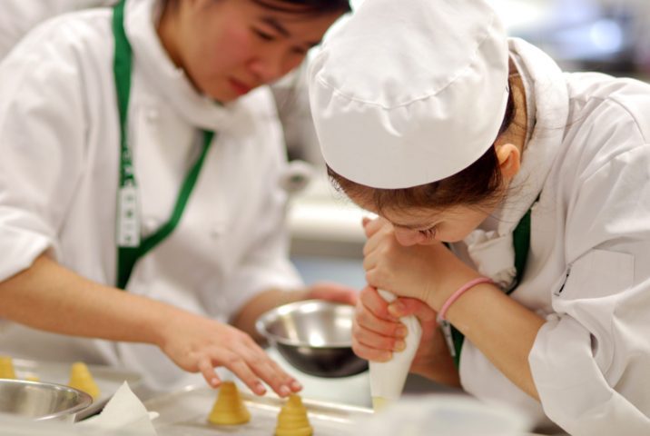 two bakers decorating cake