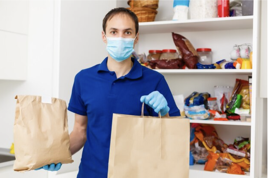 man using mask holding grocery bag https://skillmastertc.com/
