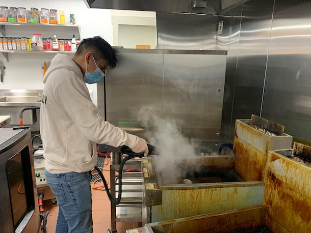 man sanitazing kitchen to maintain safety and hygiene